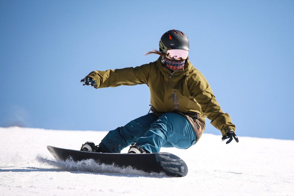 Snowboardeuse en virage sur une piste enneigée