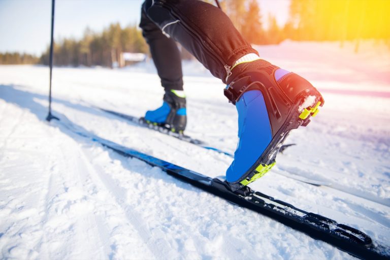 Chaussure de ski de randonnée sur la neige au soleil rasant