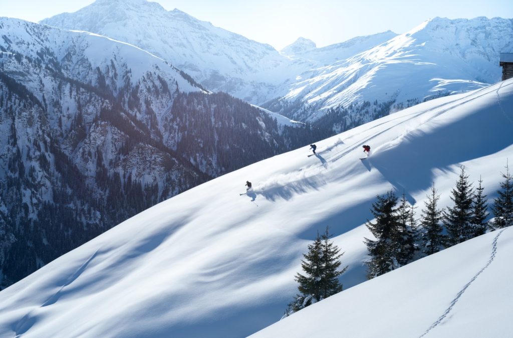 Skieurs descendant une pente enneigée en hors-piste
